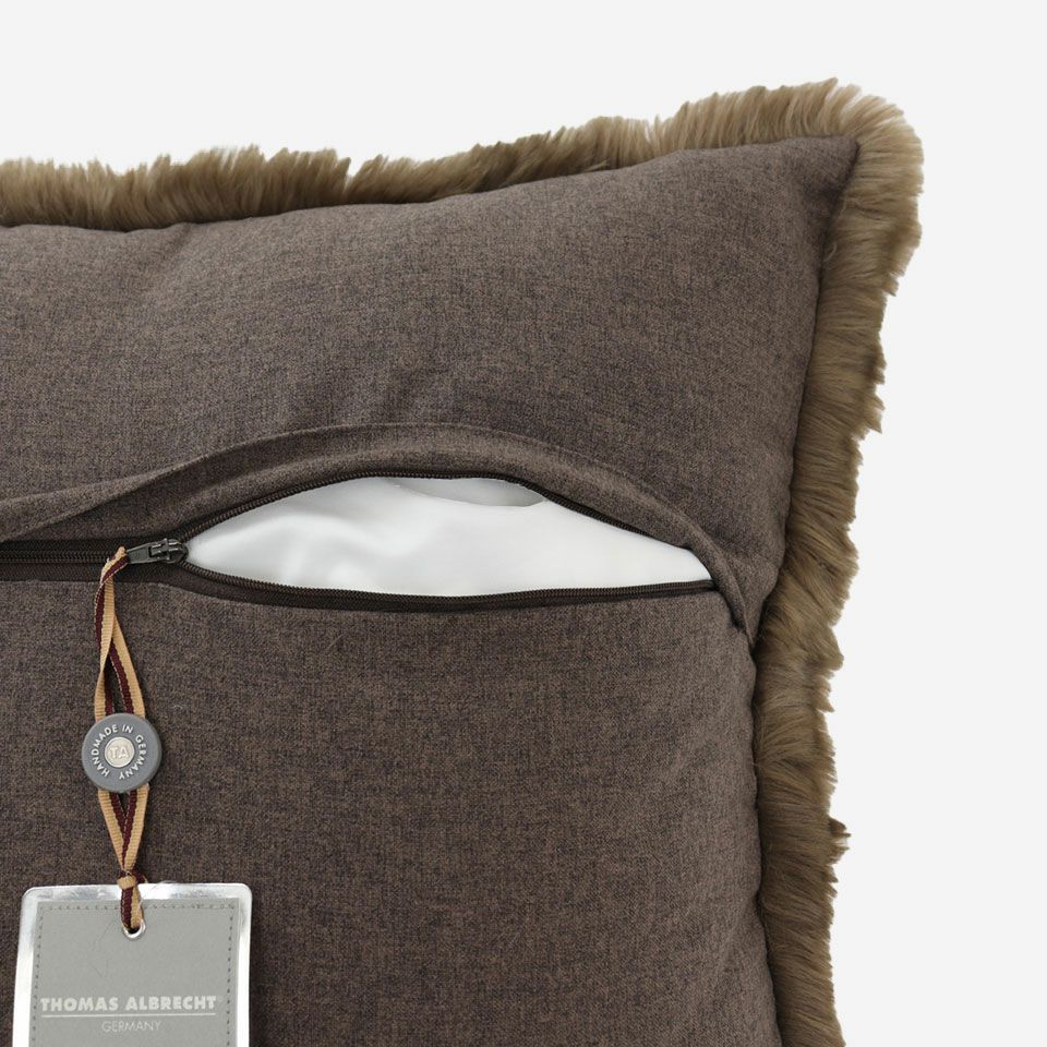 生地の色目に合わせたファスナー色を使用し、ファスナー部分に生地を片側から被せています