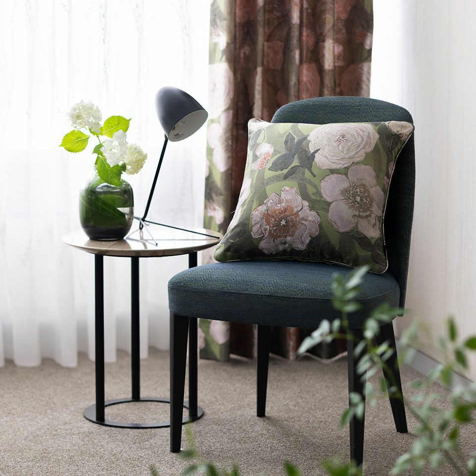 気持ちの良い緑の中で白い薔薇が風に揺れる様子を切り取ったようなクッションは、優しく癒されるような雰囲気が漂います