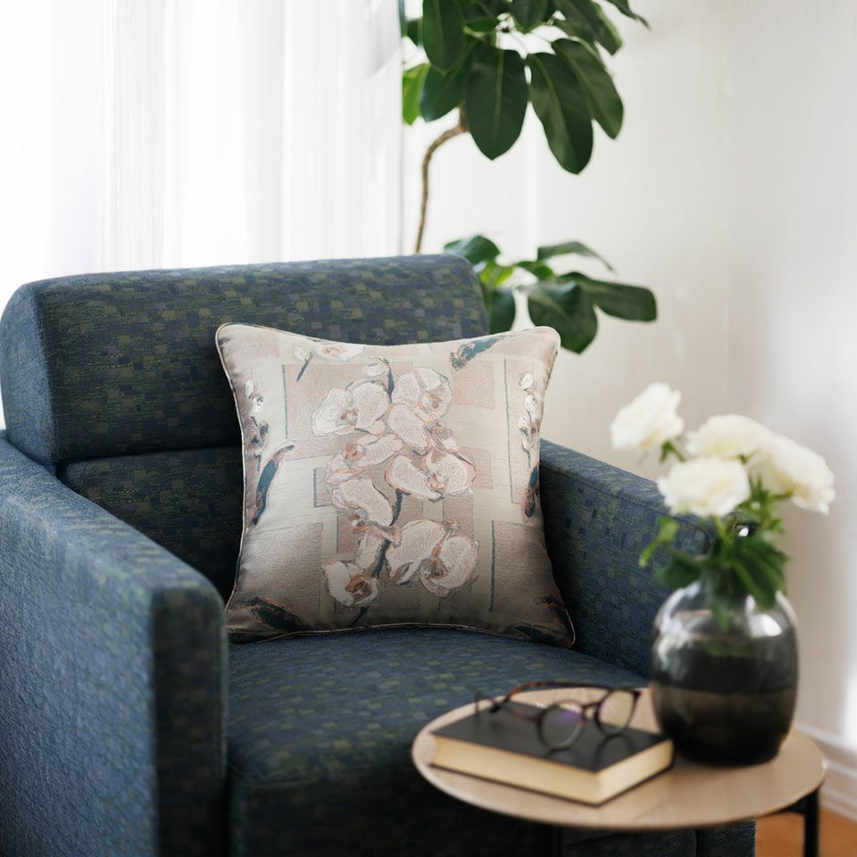 シルバー色の幾何学模様のベースに白く輝く胡蝶蘭が高貴な印象のクッションは、空間をシックに演出します