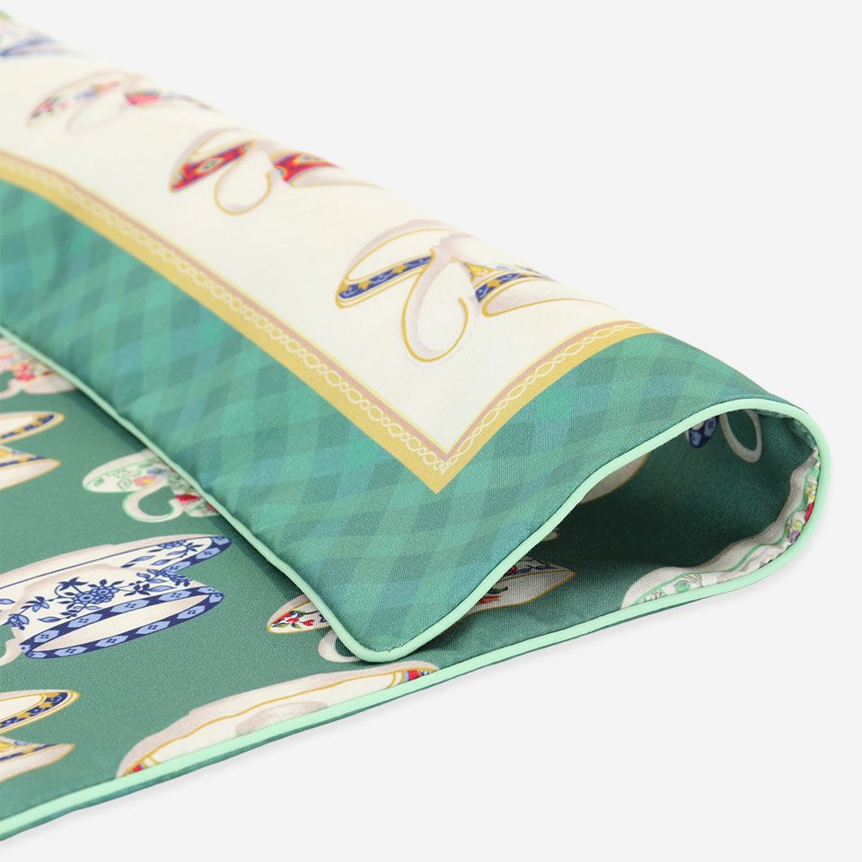 デザインは中央にカップを配し、周囲をチェックのヘムで飾った表面とカップを並べた総柄の裏面で構成されています