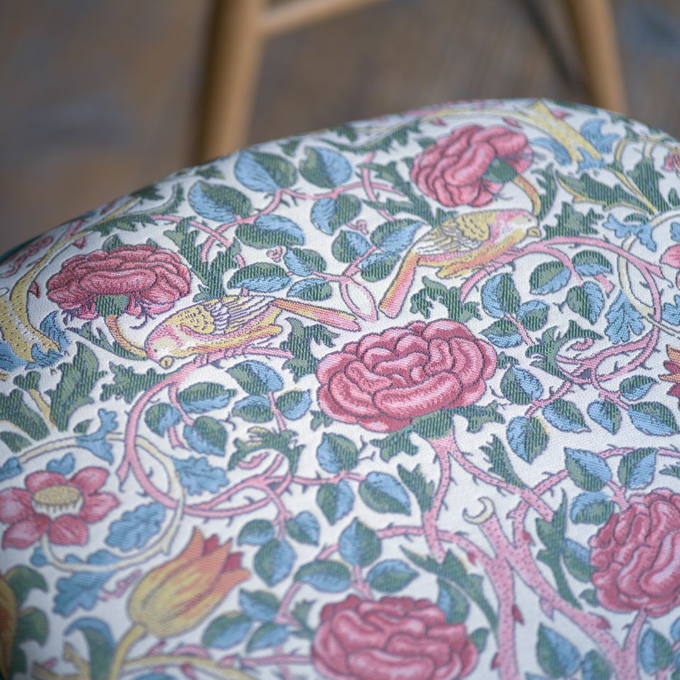 ローズは、チューリップとバラの花が豪華に咲き誇り、茂みの中で戯れる陽気な２羽の鳥がデザインされています